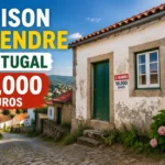 Maison portugaise simple avec façade blanche et toit rouge, située dans un village ensoleillé.
