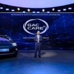 Lancement de GAC CARE+ au Salon de Paris 2026, avec un dirigeant devant une voiture électrique AION UT Cross.